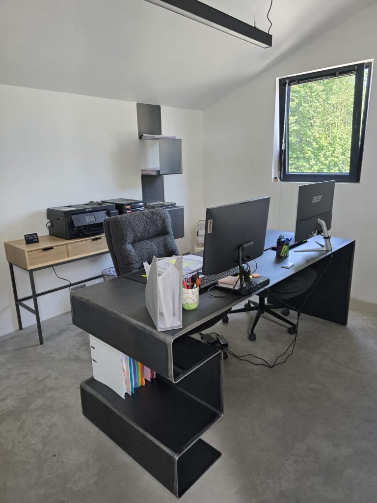 Bureau design sur mesure en acier brut vernis mat, avec piètement en Z et rangements intégrés, fabrication artisanale en Mayenne.