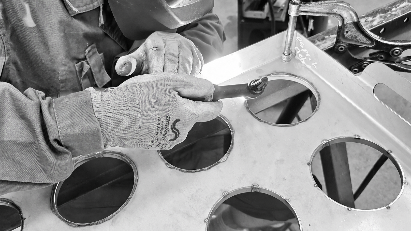 Soudure d'un plateau répartiteur en acier inoxydable sur mesure, destiné à accueillir 12 moules à fromage.