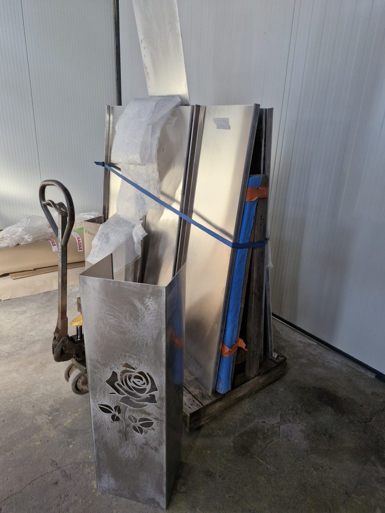 Ensemble d'habillages de fenêtres en aluminium brut plié sur mesure, dont un avec une rose décorative découpée au laser.