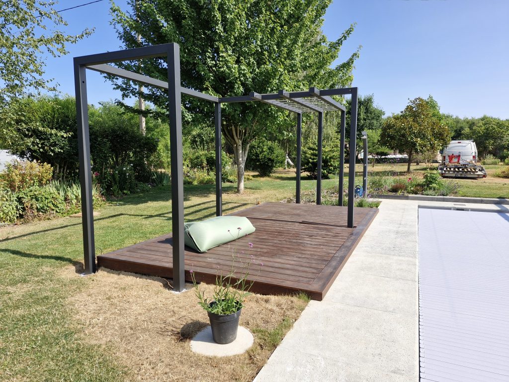 Pergola en acier sur terrasse bois au bord d’une piscine