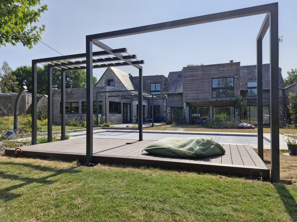 Pergola métallique sur terrasse bois au bord d’une piscine