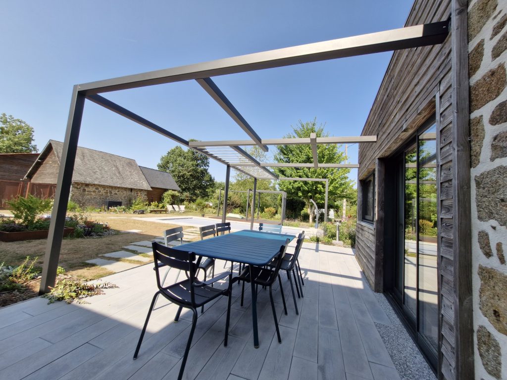 Pergola métallique sur mesure au-dessus d’une terrasse avec espace repas